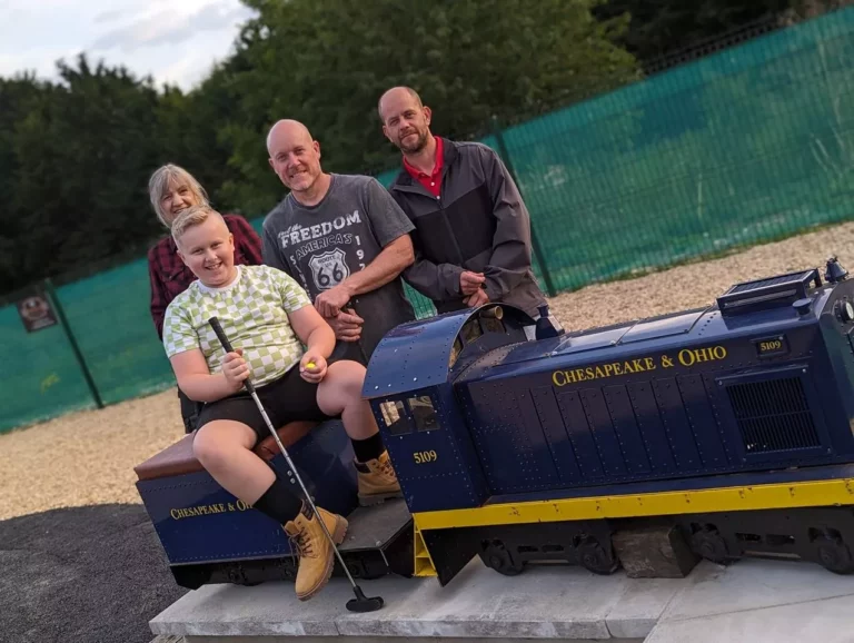 Players beside a locomotive feature at Railway Golf